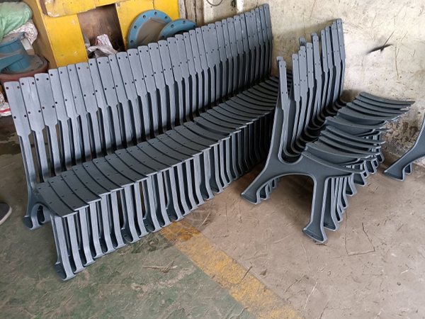 Stacked finished cast iron park bench legs, completed municipal furniture parts in factory workshop